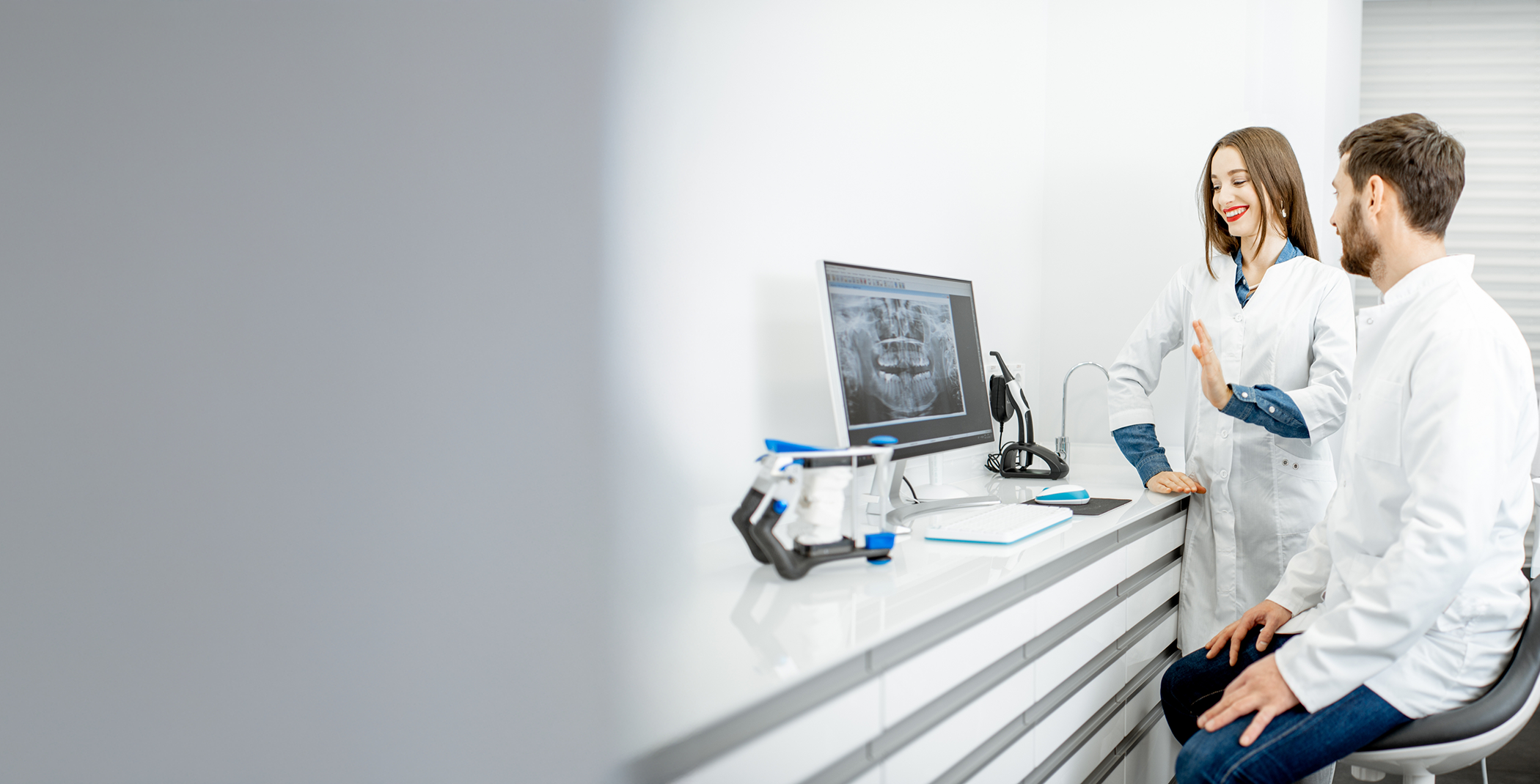 Male and female dentist looking at X-ray on laptop