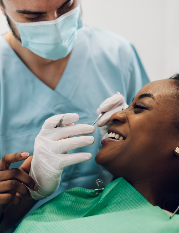 Female patient about to receive treatment from dentist wearing mask
