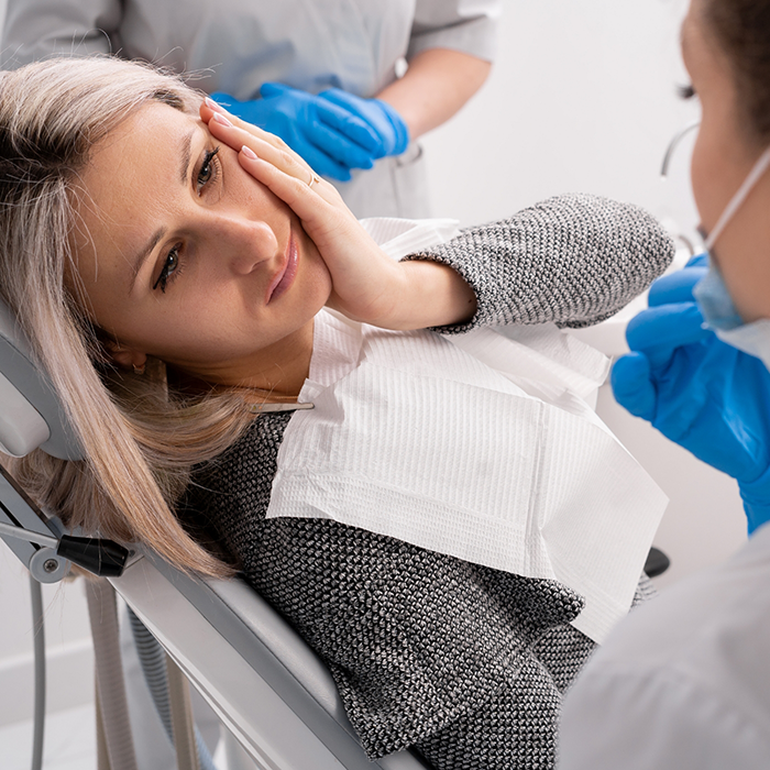 Woman with toothache looking up at dentist