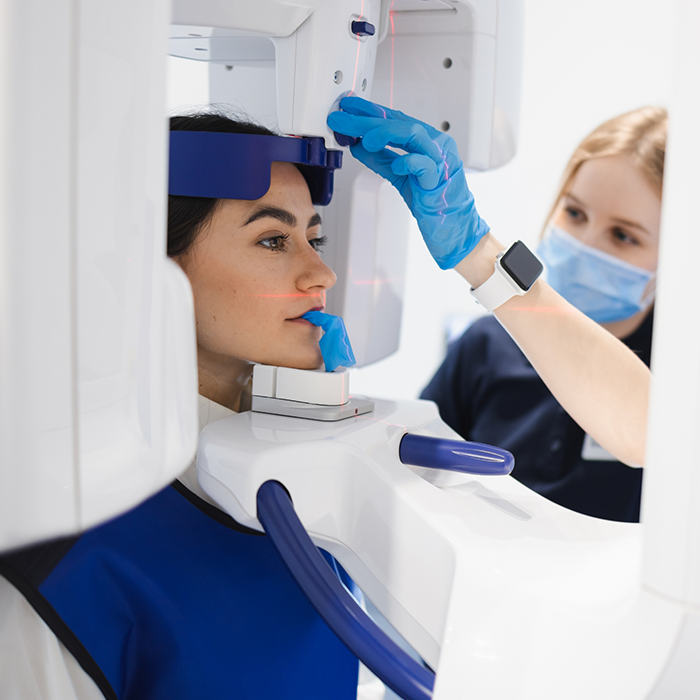 Dental team member getting patient ready for CBCT scan