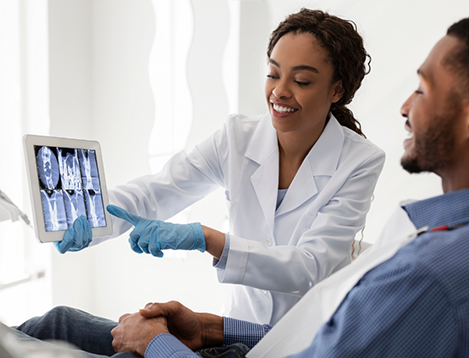 Female dentist showing male patient scan of teeth