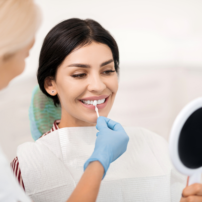 Woman having teeth shade matched for veneers