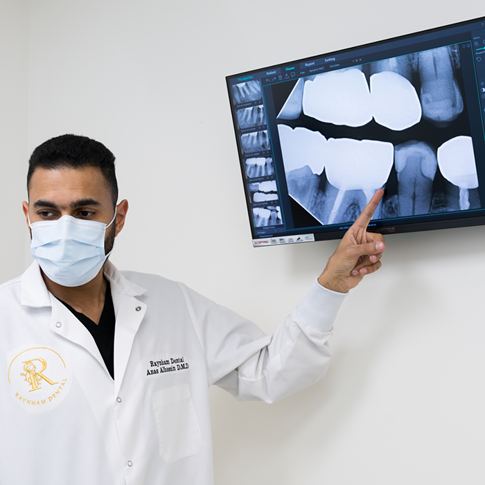 Dentist pointing to X-ray of teeth