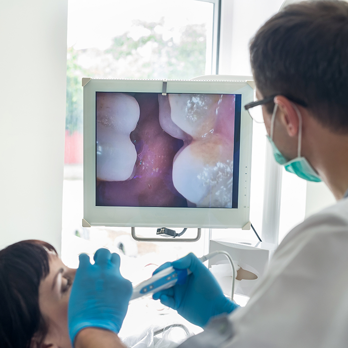 Dentist looking at scans of patient's mouth