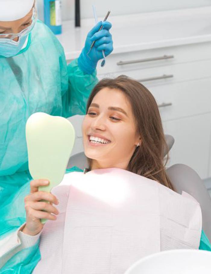 Cosmetic dentistry patient smiling at herself in mirror