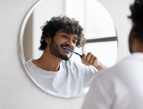 Man brushing his teeth in the mirror