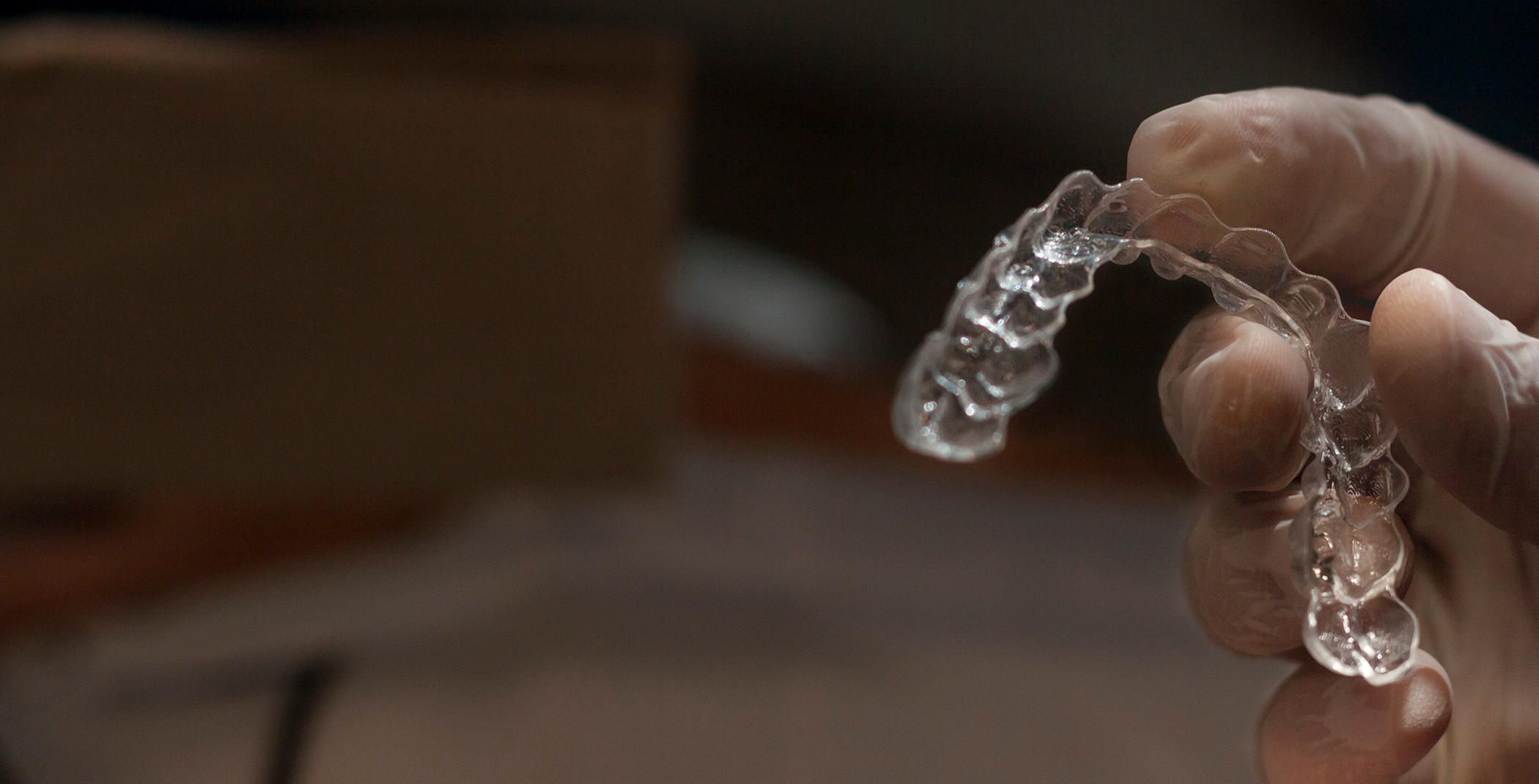 Close-up of hand holding aligner for Invisalign in Raynham