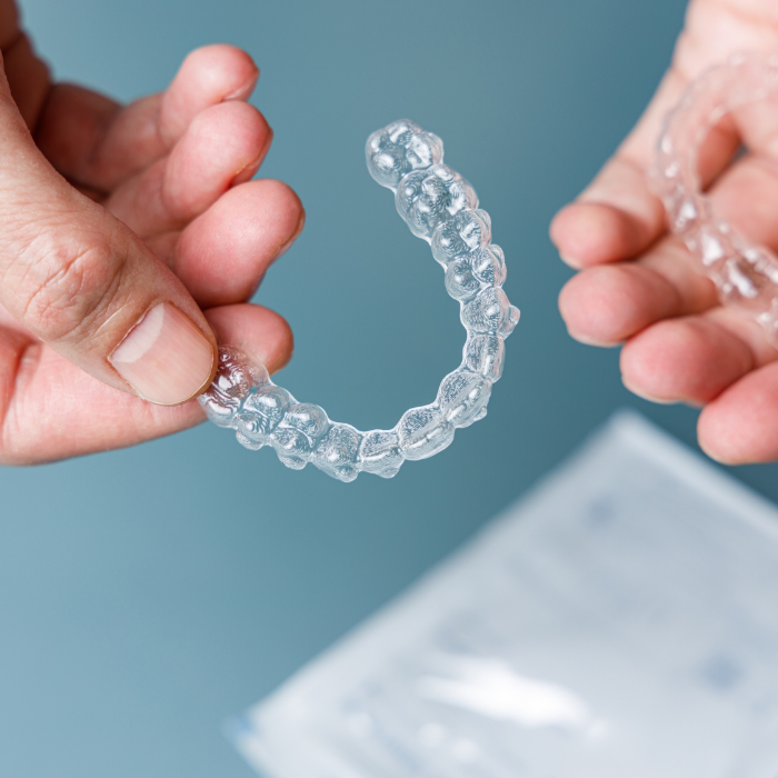 Holding Invisalign aligners over a sheet of paper