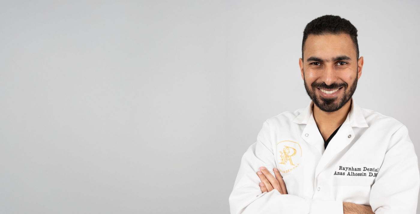 Raynham dentist Dr. Al smiling with arms folded