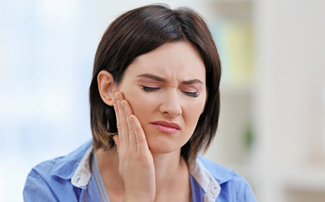 Woman rubbing her jaw in pain