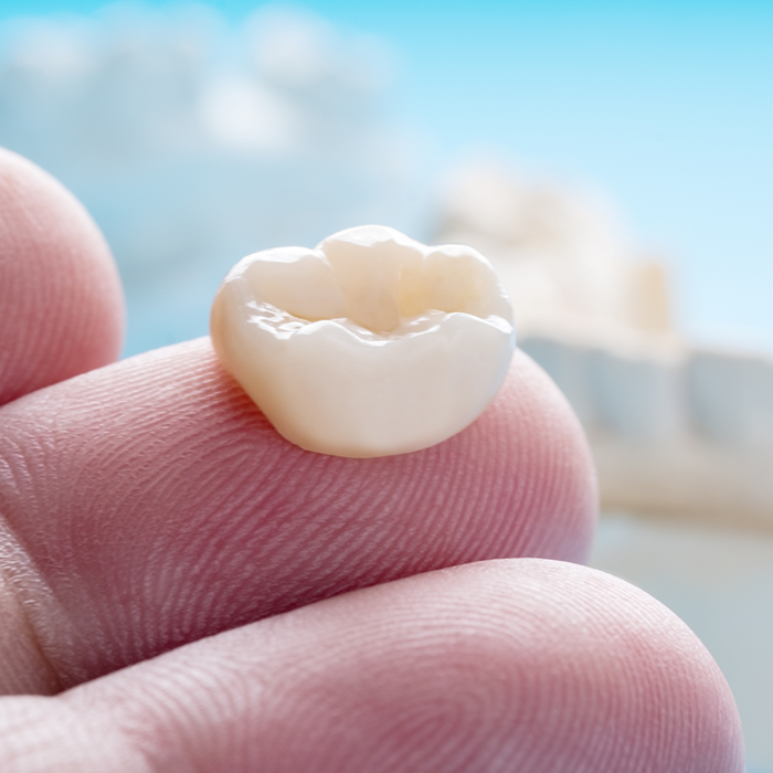 Close-up of dental crown on finger