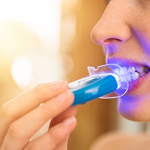 Patient in Raynham using a take-home teeth whitening kit at home 