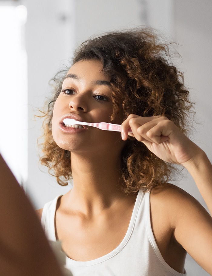 Patient in Raynham brushing after professional whitening
